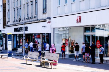 İnsanlar Marks ve Spencer Gıda Salonu için kuyruğa girip Sosyal Mesafeyi Gözlemliyor