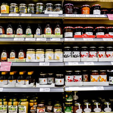 John Lewis Waitrose raflarında reçel kavanozları ve bal var.