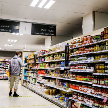 John Lewis Waitrose 'da isimsiz bir erkek müşteriyle raflarda toplanmış.