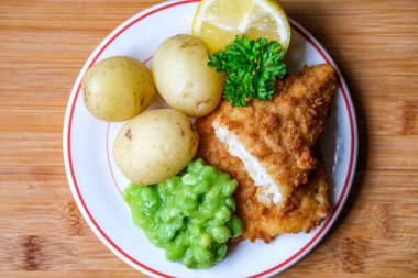 Londra İngiltere, Eylül 03, 2025, Haşlanmış Patatesli Morina filetosu ve İnsansız Lapa Bezelyesi