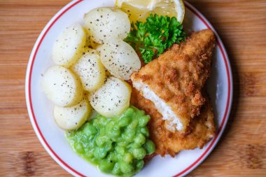 Londra İngiltere, Eylül 03, 2025, Dilimlenmiş yeni patatesli Morina filetosu ve İnsansız Lapa Bezelyesi