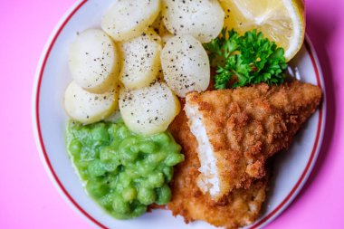 Londra İngiltere, Eylül 03, 2025, Dilimlenmiş yeni patatesli Morina filetosu ve İnsansız Lapa Bezelyesi