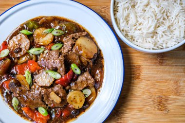 Londra İngiltere, 11 Eylül 2025, Klasik Çin usulü biftek ve haşlanmış beyaz pirinçli siyah fasulye menüsü.