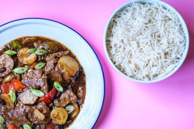 Londra İngiltere, 11 Eylül 2025, Klasik Çin usulü biftek ve haşlanmış beyaz pirinçli siyah fasulye menüsü.