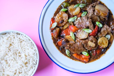 Londra İngiltere, 11 Eylül 2025, Klasik Çin usulü biftek ve haşlanmış beyaz pirinçli siyah fasulye menüsü.