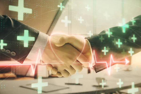 Multi exposure of heart icon hologram on office background with two men handshake. Concept of medical education — Stock Photo, Image