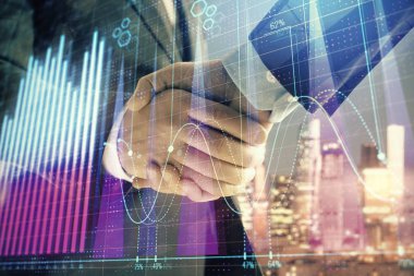 İki işadamı el sıkışması ile Cityscape arka planda mali grafik çift pozlama. Finansal analiz ve yatırım fırsatları konsepti