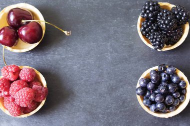 Yabanmersini, böğürtlen, kiraz ve ahududu. Böğürtlenler masada..