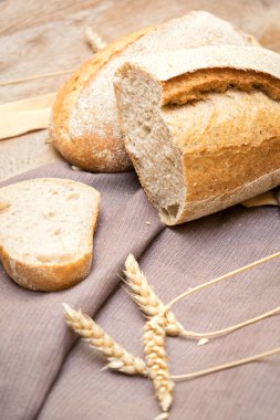 Ahşap masada, peçeteli, fırında pişirilmiş hamur işi konseptiyle pişmiş taze ekmek ve baget çeşitleri.