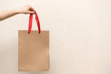 El işi alışveriş çantası tutan bir kadın. Arka planda izole edilmiş paket paketleri olan kahverengi, boş kağıtları elinde tutan kadınları kapat. Kurye servisi konsepti kopyalama alanı ile oluşturulsun