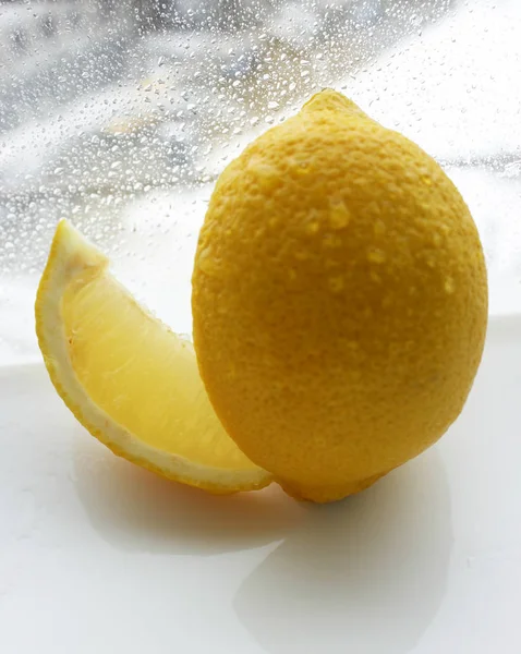 lemon on a white background. droplets of water on lemon