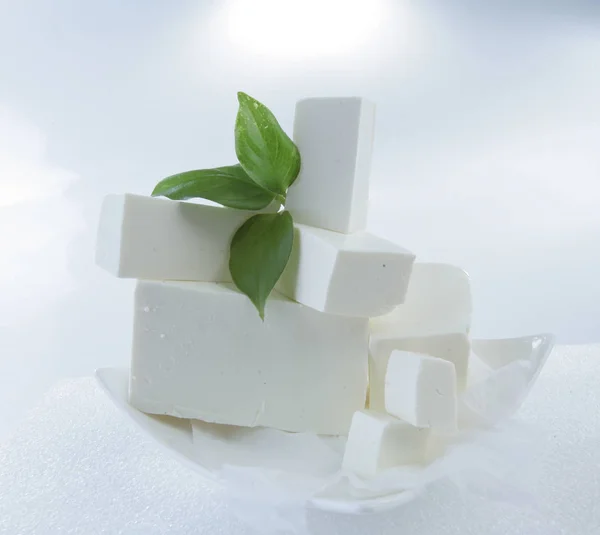  beyaz bir arka plan üzerinde beyaz peynir. Yeşil fesleğen