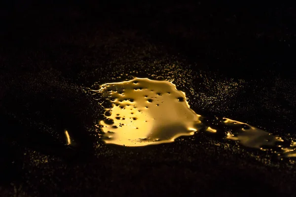 Liquid gold is spilled in a dark room — Stock Photo, Image