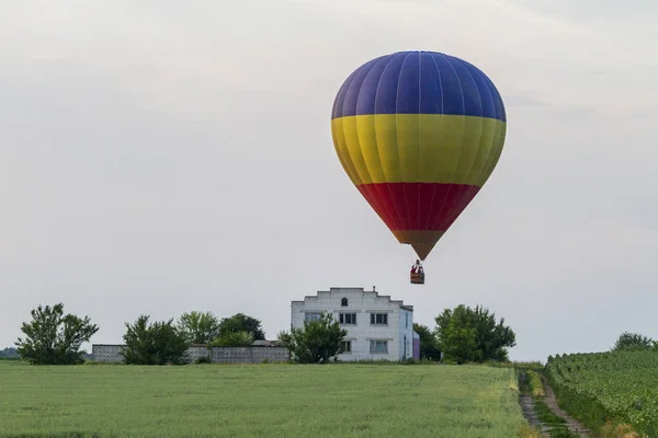 Ballon vliegt over het veld en het huis — Stockfoto