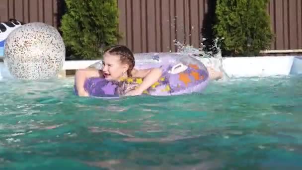 Дівчина плаває в колі в домашньому басейні — стокове відео