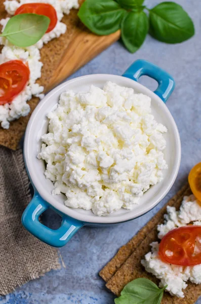 Curd cheese in a dish with toast, tomatoes and Basil. Selective focus.