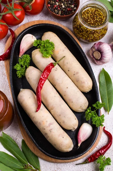 Raw white sausages with cheese and spices. Selective focus.