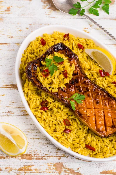 Baked Butternut squash with spicy rice on wooden background. Selective focus.