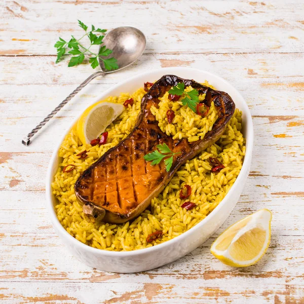 Baked Butternut squash with spicy rice on wooden background. Selective focus.