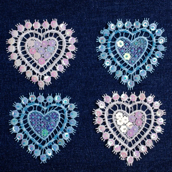 Lace decorative heart on blue denim background. Selective focus.