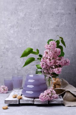 Geçmişinde bir bardakta leylak içkisi. Seçici odak.