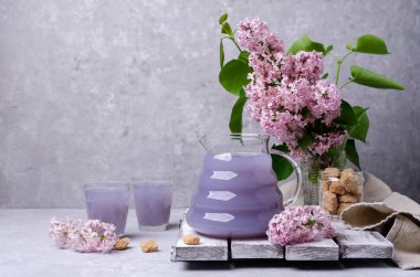 Geçmişinde bir bardakta leylak içkisi. Seçici odak.