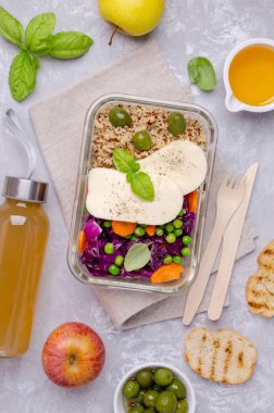 Arka planda cam beslenme çantasında kinoa ve peynirli sebze salatası. Seçici odak.