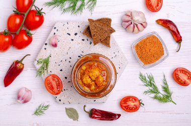 Konserve karnabahar, hafif ahşap arka planda bir kavanozda domates soslu sebze. Seçici odak.