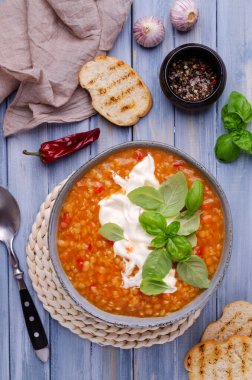 Mavi ahşap arka planda mercimek ve sebzeli kalın çorba. Seçici odak.