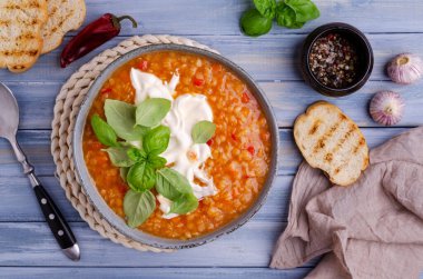 Mavi ahşap arka planda mercimek ve sebzeli kalın çorba. Seçici odak.