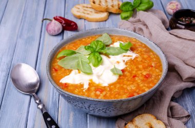 Mavi ahşap arka planda mercimek ve sebzeli kalın çorba. Seçici odak.