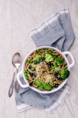 Yeşil sebzeli, zeytinli ve soslu geleneksel kahverengi makarna. Genel bakış. Seçici odak.