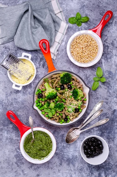 Yeşil sebzeli, zeytinli ve soslu geleneksel kahverengi makarna. Genel bakış. Seçici odak.