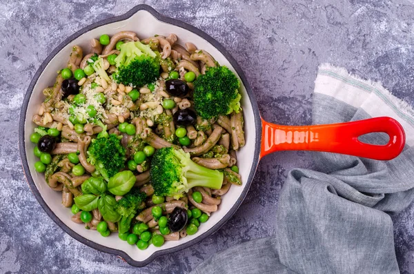 Yeşil sebzeli, zeytinli ve soslu geleneksel kahverengi makarna. Genel bakış. Seçici odak.