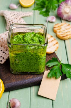 Ahşap bir arka planda cam kavanozda yeşil sos. Seçici odak.