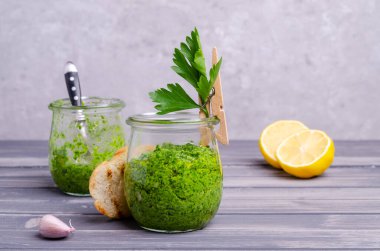 Ahşap bir arka planda cam kavanozda yeşil sos. Seçici odak.