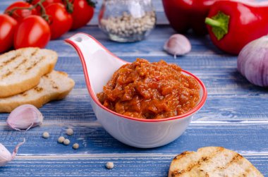 Mavi ahşap arka planda seramik bir tabakta sebze ezmesi. Seçici odak.