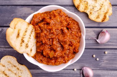 Gri ahşap arka planda seramik bir tabakta sebze ezmesi. Seçici odak.