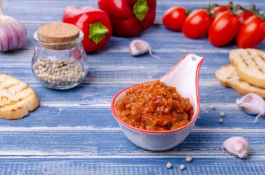 Mavi ahşap arka planda seramik bir tabakta sebze ezmesi. Seçici odak.