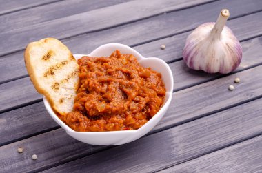 Gri ahşap arka planda seramik bir tabakta sebze ezmesi. Seçici odak.