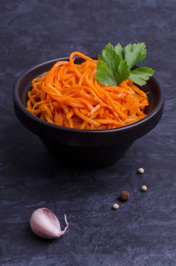 Koyu taştan bir arka planda baharatlı havuç salatası. Seçici odak.