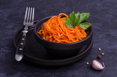 Koyu taştan bir arka planda baharatlı havuç salatası. Seçici odak.