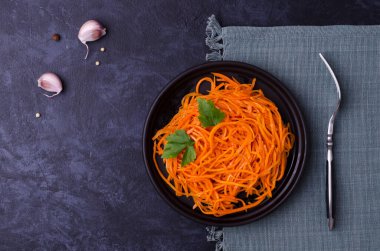 Koyu taştan bir arka planda baharatlı havuç salatası. Seçici odak.