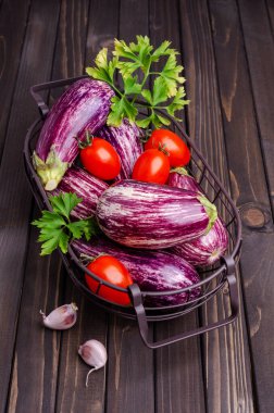 Koyu ahşap arka planda metal bir sepette çiğ sebzeler. Seçici odak.