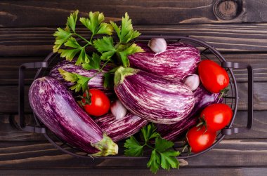 Koyu ahşap arka planda metal bir sepette çiğ sebzeler. Seçici odak.