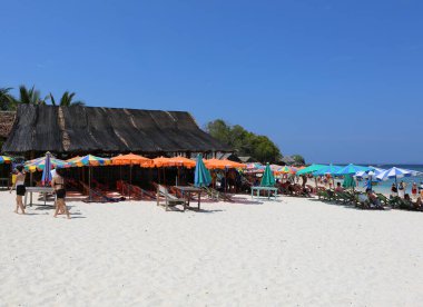 Phuket, Tayland-Nisan 03.2016: Kimliği belirlenemeyen kişiler, Khai nai Adası 'nda yürüyen ve yüzen bazı kişiler, Restoran binasının yanındaki plaj sandalyelerinde oturuyorlar