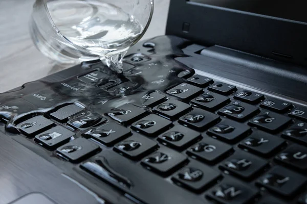 水不小心洒在笔记本电脑上了 键盘充满了液体 计算机坏了 免版税图库图片