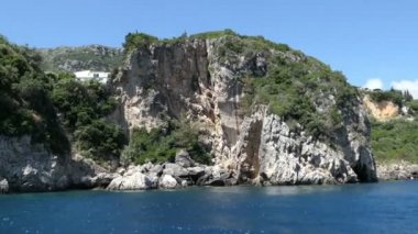 bir tekne ile Korfu Adası (Yunanistan)'nda Liapades plaja Paleokastritsa sürüş. sediiment tebeşir kayalar su tarafından geçen. Cliff Sahil Orman ile.