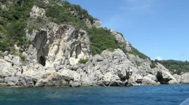 Paleokastritsa tekne gezisinden Liapades beach Korfu Adası (Yunanistan), doğru. tortu tebeşir kayalar su tarafından geçen. Cliff Sahil Orman ile.