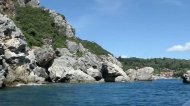Paleokastritsa tekne gezisinden Liapades beach Korfu Adası (Yunanistan), doğru. tortu tebeşir kayalar su tarafından geçen. Cliff Sahil Orman ile.
